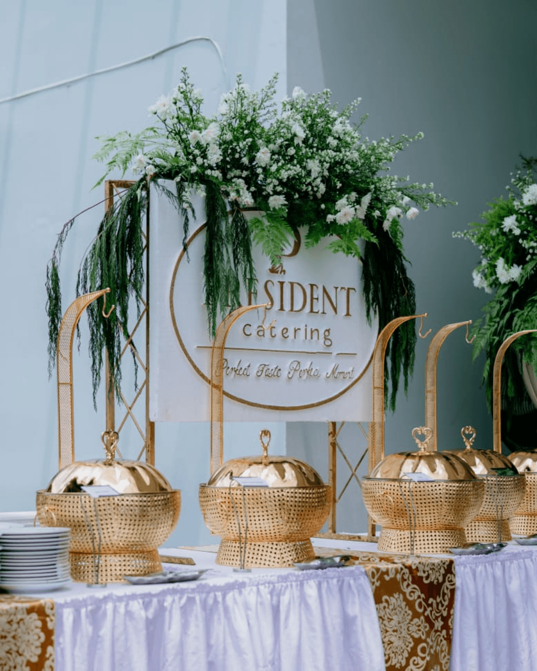 Area buffet pernikahan President Catering dengan dekorasi hijau dan putih.